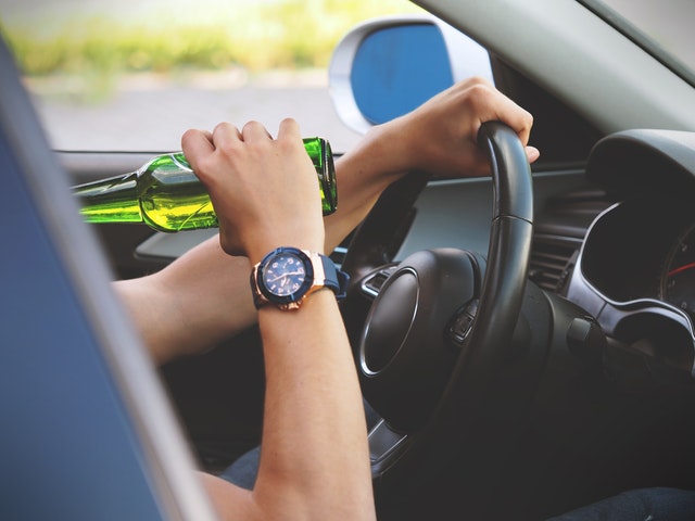 image of adult driving while drinking