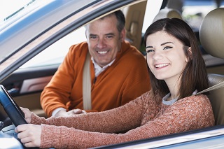 image of dad teaching daughter how to drive